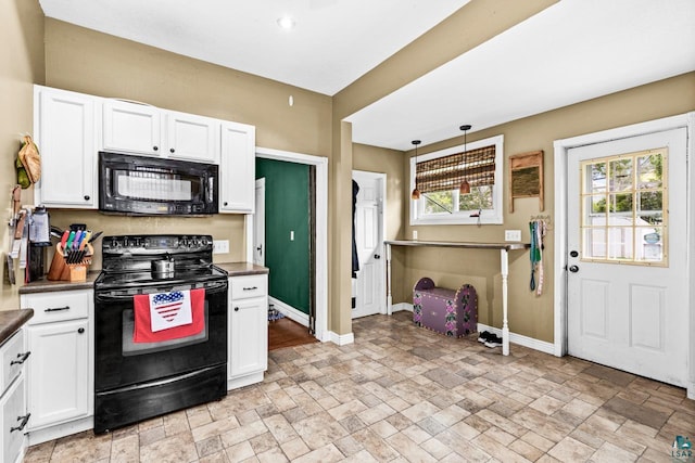 3801 W 5th St, Duluth, MN 55807 - kitchen with black appliances, dark countertops, stone tile flooring, white cabinets, and pendant lighting