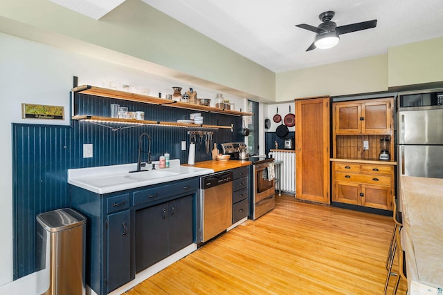 31 W 5th St, Duluth, MN 55806 - kitchen featuring appliances with stainless steel finishes, light countertops, light wood-style flooring, a ceiling fan, and brown cabinetry
