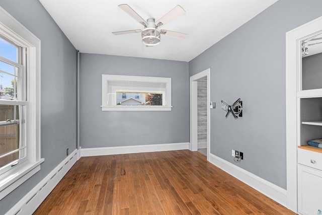 996 85th Ave W, Duluth, MN 55808 - unfurnished room with a baseboard heating unit, healthy amount of natural light, wood finished floors, and ceiling fan