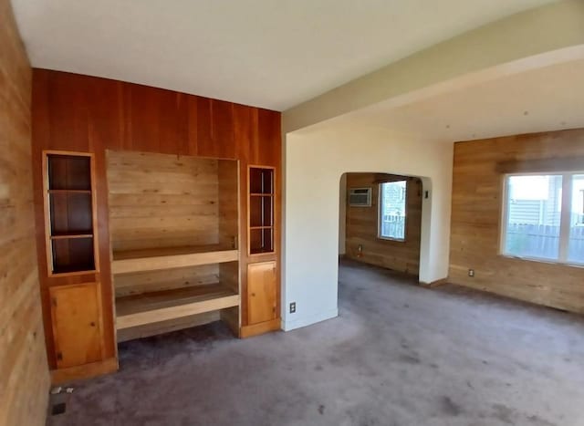 112 W 3rd Ave N, Aurora, MN 55705 - unfurnished bedroom with wood walls, arched walkways, carpet, and a wall unit AC