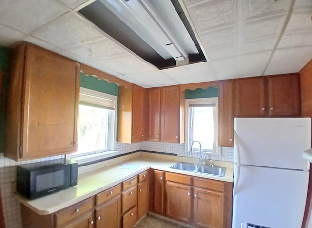 112 W 3rd Ave N, Aurora, MN 55705 - kitchen with freestanding refrigerator, black microwave, light countertops, and brown cabinets