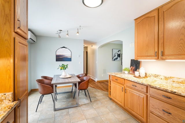 318 Marshall St, Duluth, MN 55803 - kitchen featuring a wall mounted AC, arched walkways, light stone counters, and light tile patterned floors