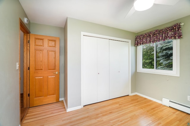 318 Marshall St, Duluth, MN 55803 - unfurnished bedroom with baseboard heating, light wood-style flooring, a closet, and a ceiling fan