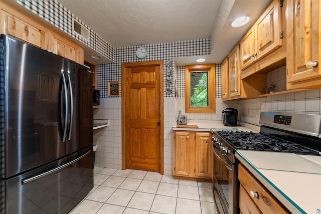 4930 Mini Power Rd, Duluth, MN 55803 - kitchen with freestanding refrigerator, stainless steel gas range, light countertops, light tile patterned floors, and open shelves