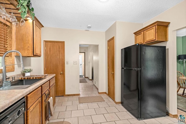 1025 W 3rd St, Duluth, MN 55806 - kitchen with black appliances, brown cabinets, light countertops, light tile patterned floors, and a textured ceiling