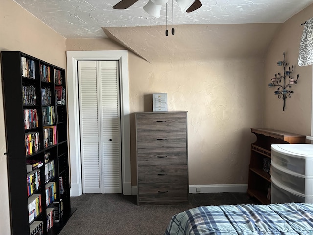 9235 Meadow St, Duluth, MN 55810 - bedroom with dark carpet, a closet, a ceiling fan, vaulted ceiling, and a textured wall