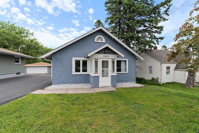 2420 Piedmont Ave, Duluth, MN 55811 - view of front of house featuring stucco siding, a front lawn, an outbuilding, and a detached garage