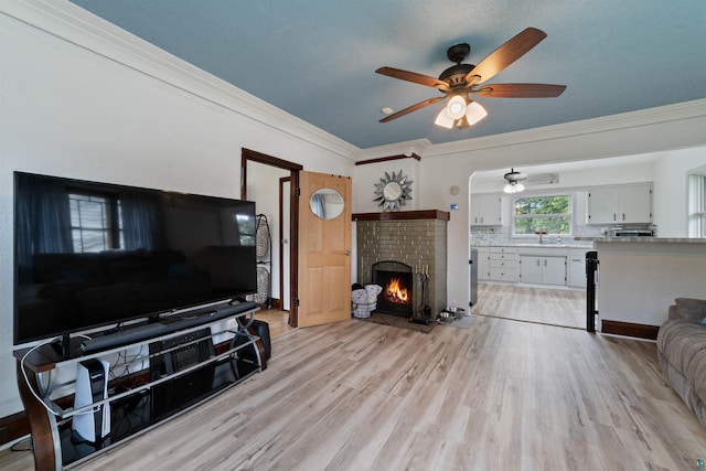 2420 Piedmont Ave, Duluth, MN 55811 - living room with ceiling fan, a brick fireplace, light wood-type flooring, and crown molding