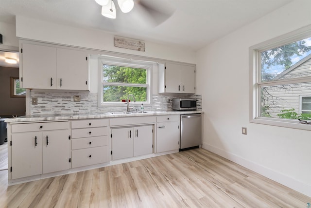 2420 Piedmont Ave, Duluth, MN 55811 - kitchen featuring stainless steel appliances, tasteful backsplash, light countertops, ceiling fan, and light wood-type flooring