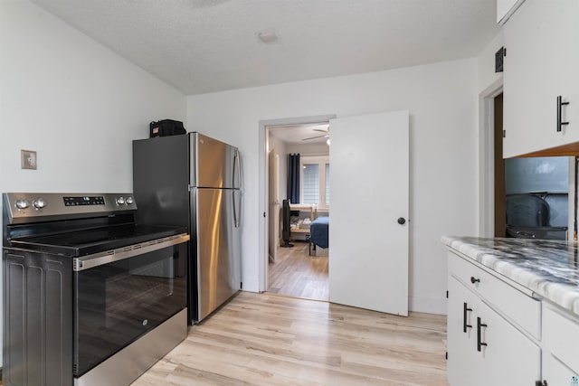2420 Piedmont Ave, Duluth, MN 55811 - kitchen featuring stainless steel appliances, light wood-style floors, white cabinetry, and a ceiling fan