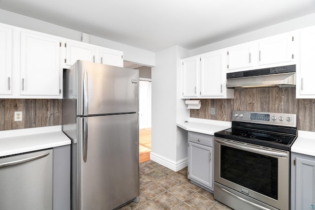 41 Cato Ave, Duluth, MN 55808 - kitchen featuring appliances with stainless steel finishes, under cabinet range hood, light countertops, light tile patterned flooring, and white cabinetry