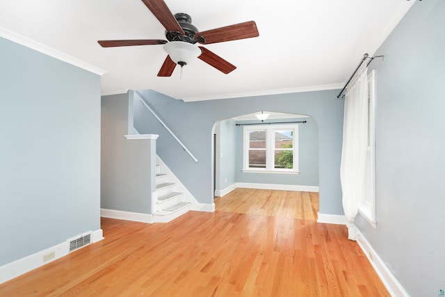41 Cato Ave, Duluth, MN 55808 - empty room featuring ornamental molding, arched walkways, light wood finished floors, stairs, and ceiling fan