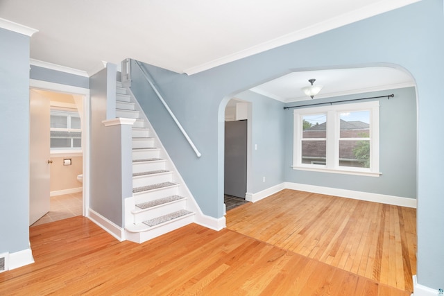 41 Cato Ave, Duluth, MN 55808 - unfurnished living room featuring hardwood / wood-style flooring, ornamental molding, arched walkways, and stairway