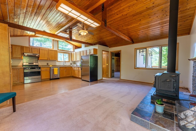 1475 Echo Trl, Ely, MN 55731 - kitchen with stainless steel appliances, light colored carpet, a wood ceiling with exposed beams, a wood stove, and a ceiling fan