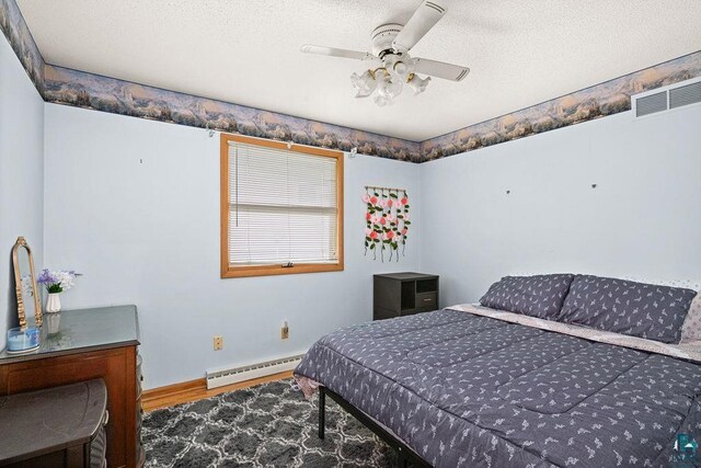 5525 Highland St, Duluth, MN 55807 - bedroom with a baseboard radiator, wood finished floors, a textured ceiling, and ceiling fan