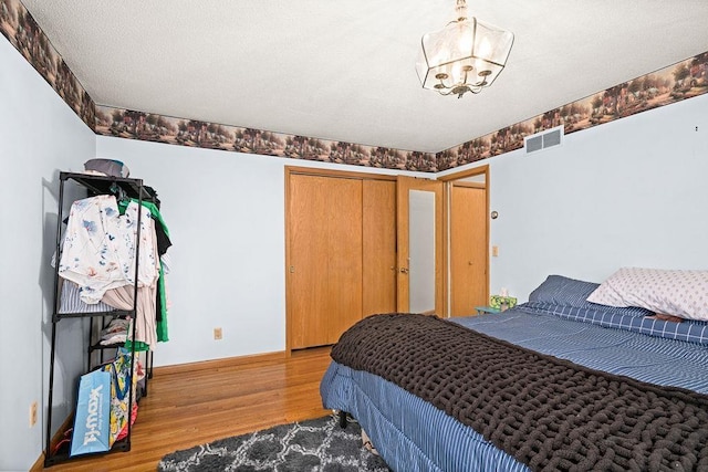 5525 Highland St, Duluth, MN 55807 - bedroom with wood finished floors, a chandelier, and a closet