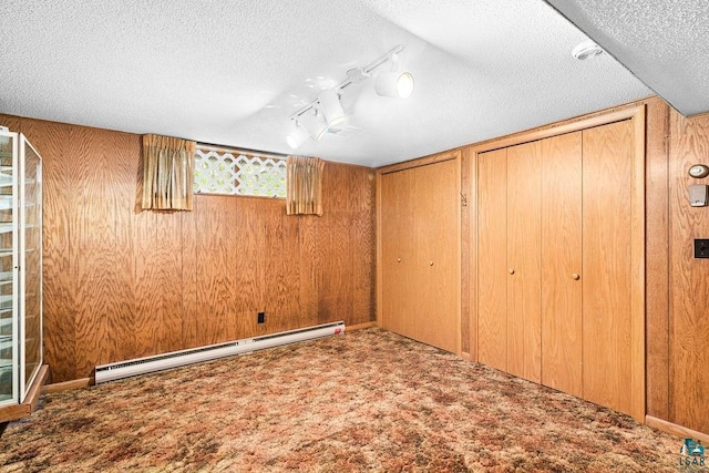 5525 Highland St, Duluth, MN 55807 - below grade area with a baseboard heating unit, carpet flooring, a textured ceiling, wood walls, and track lighting