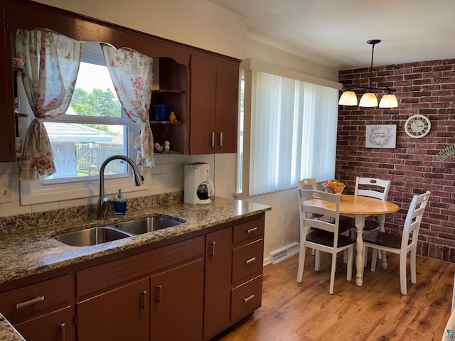 1264 92nd Ave W, Duluth, MN 55808 - kitchen with healthy amount of natural light, open shelves, light wood finished floors, light stone counters, and brick wall