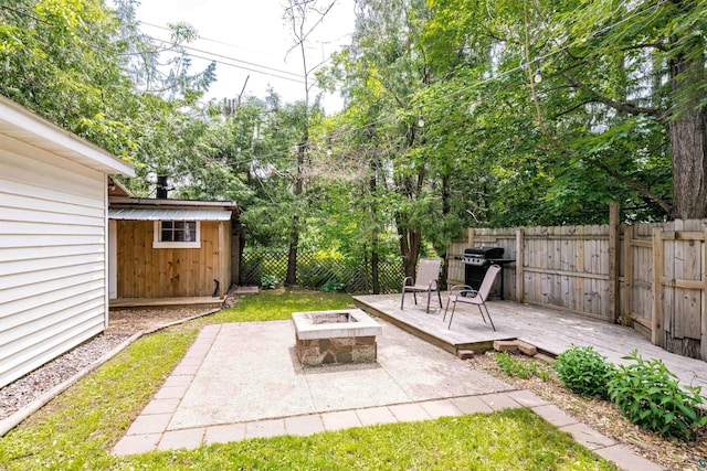 136 W Winona St, Duluth, MN 55803 - fenced backyard with an outdoor fire pit, a wooden deck, area for grilling, a patio, and a storage unit