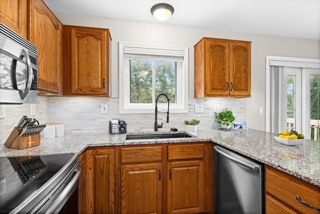 1207 Jean Marie St, Cloquet, MN 55720 - kitchen with appliances with stainless steel finishes, plenty of natural light, light stone counters, and decorative backsplash