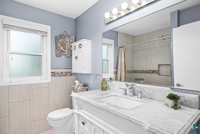 1207 Jean Marie St, Cloquet, MN 55720 - bathroom with healthy amount of natural light, vanity, a tile shower, a wainscoted wall, and tile walls