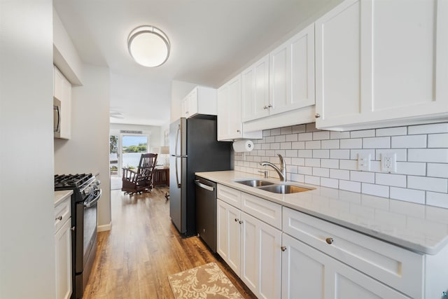 524 Marina Dr Unit 524, Superior, WI 54880 - kitchen with stainless steel appliances, backsplash, light wood finished floors, white cabinetry, and light stone countertops