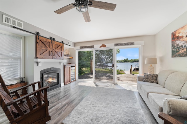 524 Marina Dr Unit 524, Superior, WI 54880 - living area featuring a water view, wood finished floors, ceiling fan, a barn door, and a glass covered fireplace