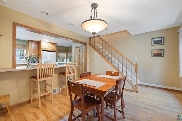 2323 Catskill St, Duluth, MN 55811 - dining room with light wood-style flooring, stairs, and a textured ceiling