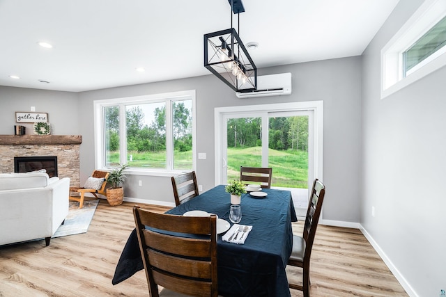 5122 Hermantown Rd Unit 5122, Hermantown, MN 55810 - dining space featuring a wall unit AC, light wood finished floors, a stone fireplace, and recessed lighting