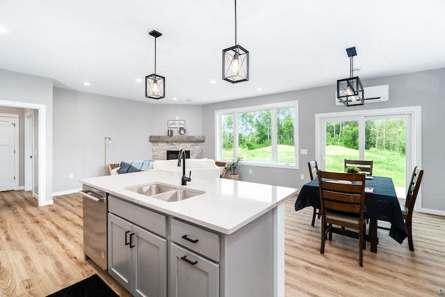 5122 Hermantown Rd Unit 5122, Hermantown, MN 55810 - kitchen with gray cabinets, stainless steel dishwasher, a stone fireplace, light countertops, and light wood-style floors