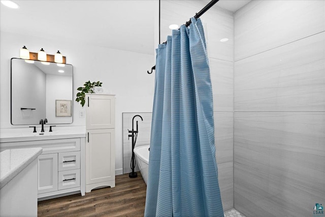 4414 Midway Rd, Hermantown, MN 55811 - full bathroom featuring vanity, a freestanding bath, tiled shower, and wood finished floors