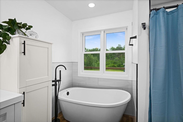 4414 Midway Rd, Hermantown, MN 55811 - bathroom featuring wood finished floors, a soaking tub, and tile walls