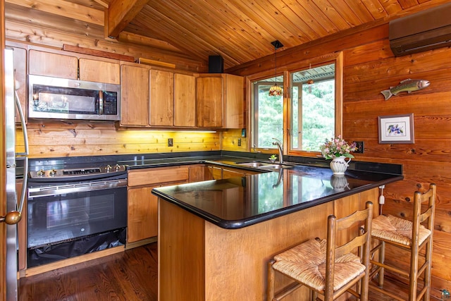 3206 Shady Rst, Ely, MN 55731 - kitchen with stainless steel appliances, an AC wall unit, wooden ceiling, dark countertops, and wood walls