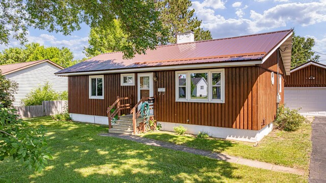 53 Dogwood Blvd, Babbitt, MN 55706 - view of front of house with a chimney, an outbuilding, a metal roof, and a garage