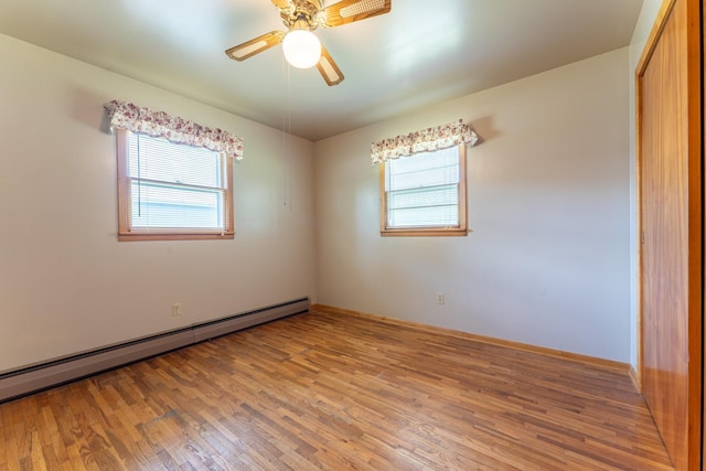8702 Sock Lake Rd, Babbitt, MN 55706 - empty room featuring a baseboard heating unit, plenty of natural light, wood finished floors, and ceiling fan