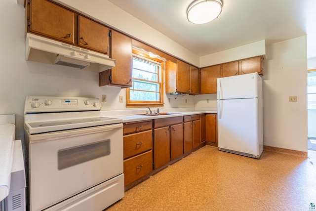 8702 Sock Lake Rd, Babbitt, MN 55706 - kitchen featuring white appliances, under cabinet range hood, brown cabinets, and light countertops