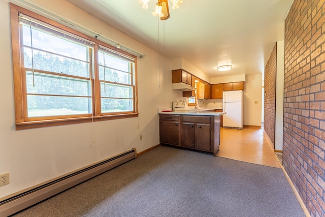 8702 Sock Lake Rd, Babbitt, MN 55706 - kitchen with freestanding refrigerator, a baseboard radiator, brick wall, a peninsula, and under cabinet range hood