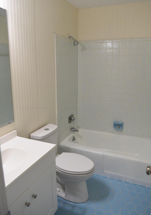 full bathroom featuring toilet, vanity, tile patterned floors, and tiled shower / bath combo