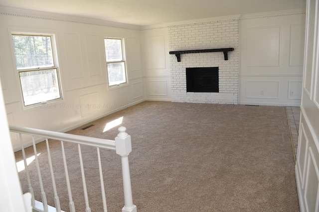 unfurnished living room with carpet flooring, a brick fireplace, and a healthy amount of sunlight