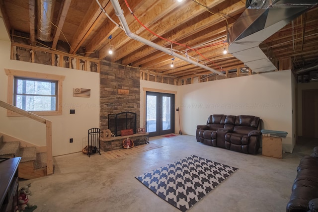 living room with concrete floors, a wealth of natural light, and french doors