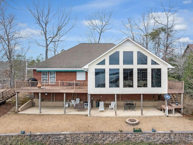 rear view of property featuring a fire pit, a patio, a deck, and stairway