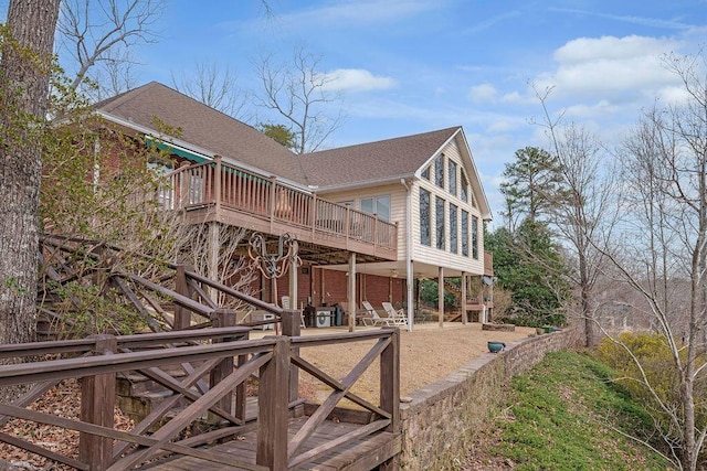 view of home's exterior featuring a wooden deck and roof with shingles