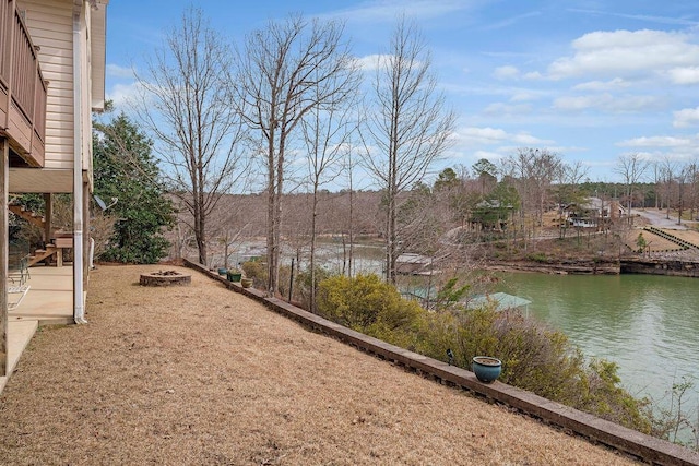 view of yard featuring a water view, an outdoor fire pit, and stairway