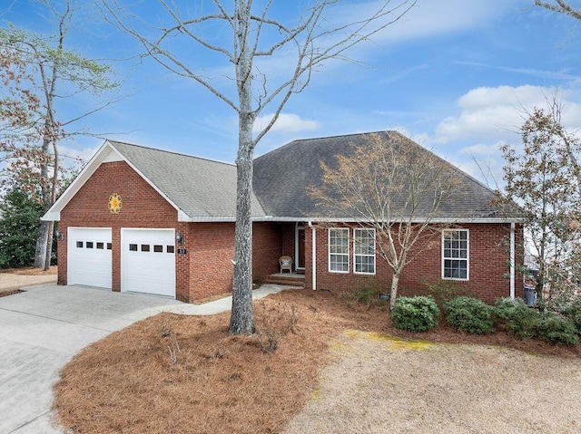 ranch-style home with an attached garage, driveway, roof with shingles, and brick siding