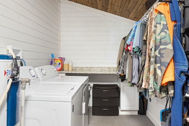 laundry room featuring wood ceiling, washer and dryer, and wood walls