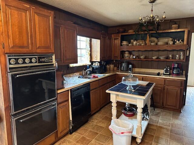 kitchen featuring pendant lighting, sink, an inviting chandelier, black appliances, and a textured ceiling