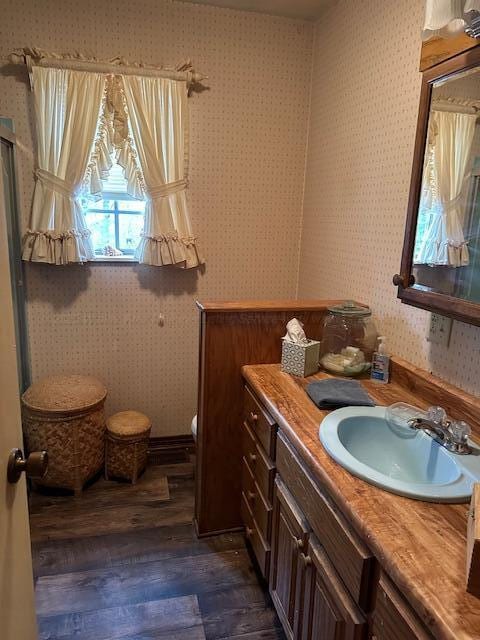 bathroom featuring wood-type flooring, toilet, and vanity