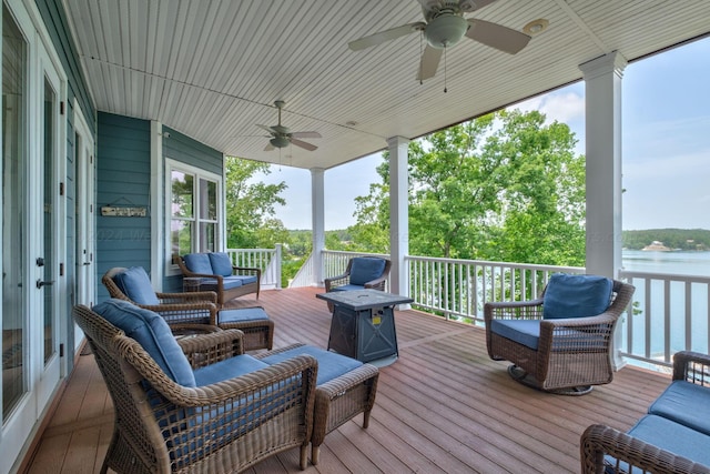 wooden terrace featuring ceiling fan, a water view, and an outdoor hangout area