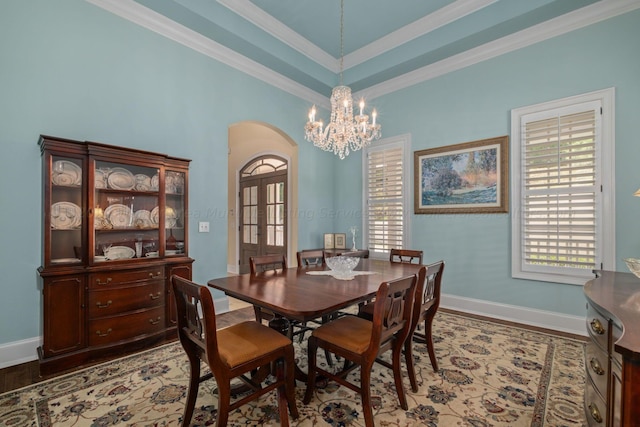 dining area featuring a chandelier, hardwood / wood-style floors, french doors, and crown molding