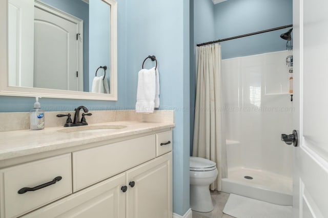 bathroom featuring tile patterned floors, vanity, curtained shower, and toilet